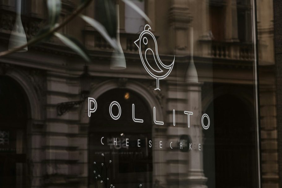 rotulación de comercios, impresión de vinilos en Miraflores de la sierra Logo de "Pollito" con un dibujo de un pollito en un fondo arquitectónico.