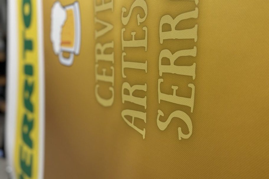 impresión de lonas soto del real Texto con el nombre "Cerveza Artesanal Serritón" sobre fondo amarillo.