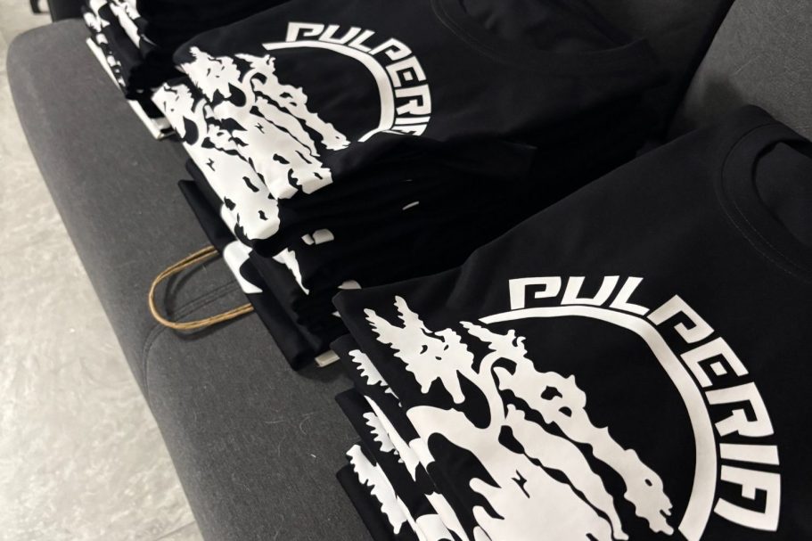 personalización textil, camisetas, sudaderas, en Miraflores de la sierra Camisas negras apiladas con un diseño gráfico blanco en la parte frontal.